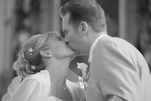 hochzeitsfotografie schwarz-weiss brautpaar vor dem altar sich innig küssend