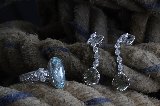 schmuck still life, Fingerring mit grossem, hellblauen Stein im Diamantschliff sowie zwei Ohr-Hängern auf altem Seil