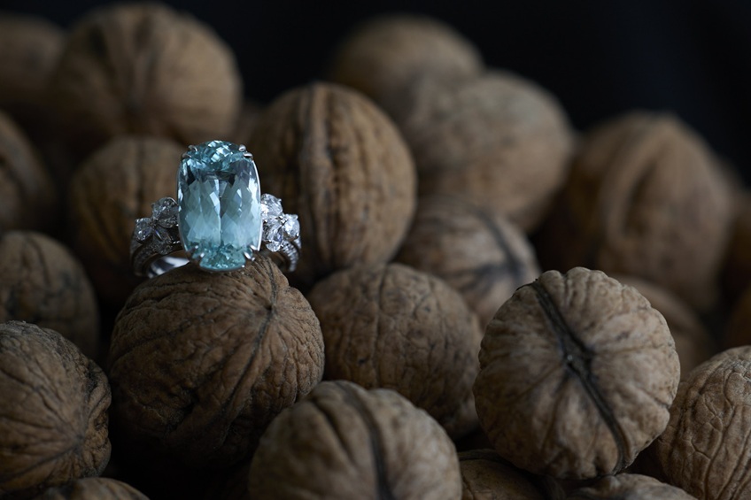 Schmuck Still life, Fingerring mit grossem hellblauen Stein in Diamantschliff auf Baumnüssen