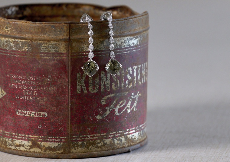 still life von alter blechbüchse mit zwei diamant-ohr-hängern / schmuck
