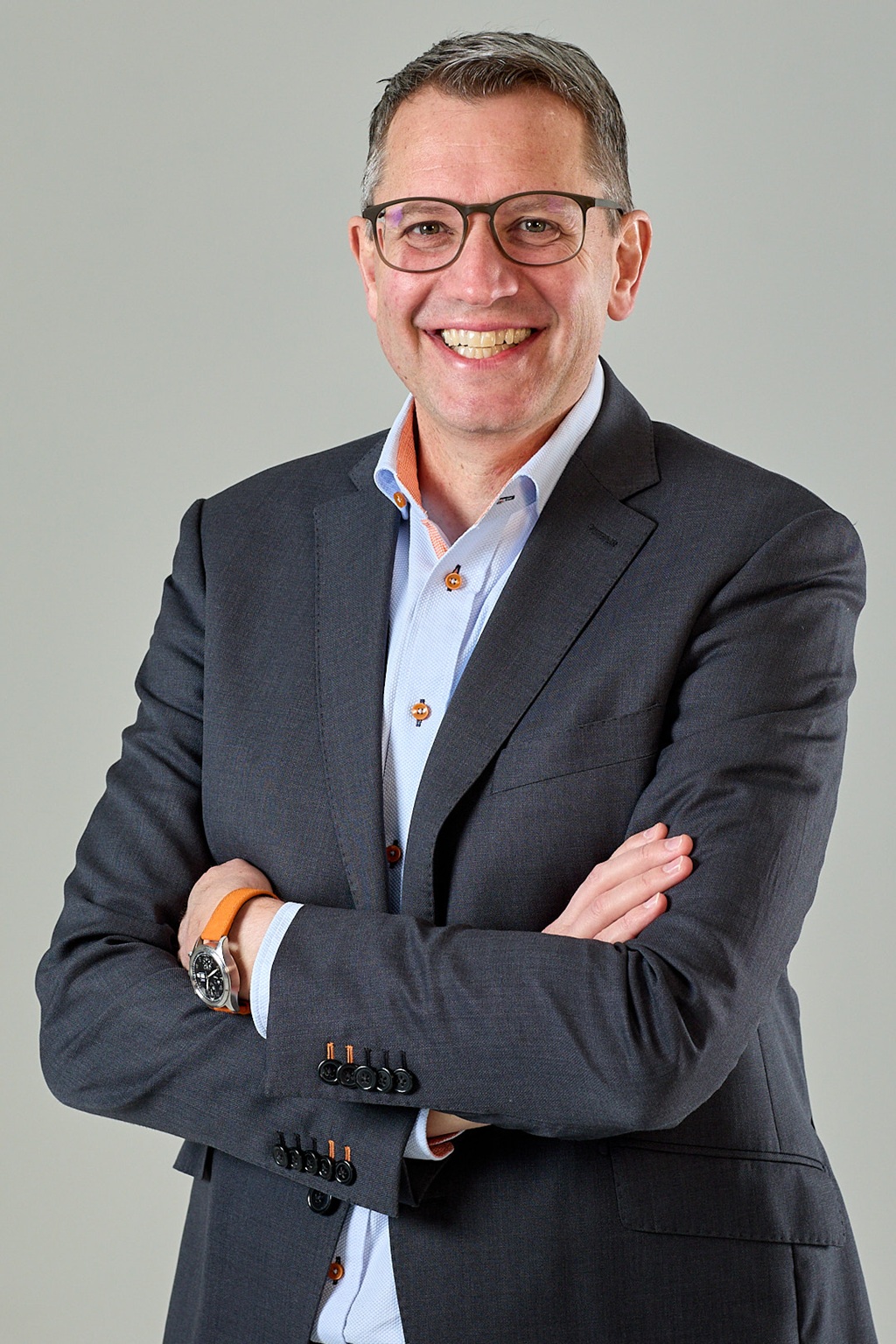 Herr um 50 Jahre mit hellblauem hemd und grauem Veston und kurzem dunklem haar, lächelnd businessportrait marc keller